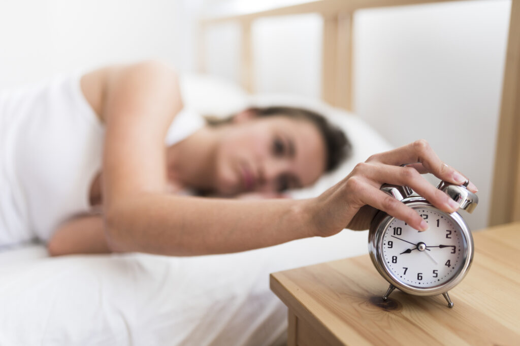 woman-lying-bed-turning-off-alarm-clock-bedroom woman-lying-bed-turning-off-alarm-clock-bedroom